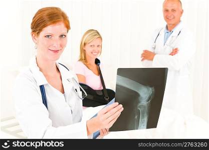 Medical doctors show x-ray hospital patient in bed broken arm