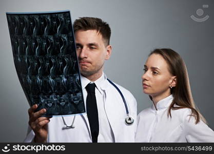 Medical doctors team with MRI spinal scan portrait against grey background