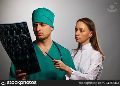 Medical doctors team with MRI spinal scan portrait against grey background