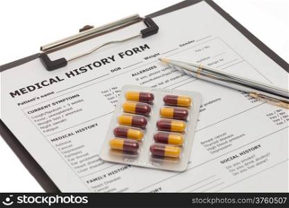 Medical document on clipboard with pills