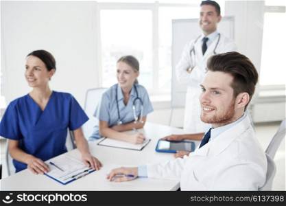 medical education, health care, medical education, people and medicine concept - group of happy doctors or interns with mentor meeting on presentation at hospital