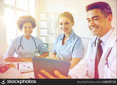 medical education, health care, people, technology and medicine concept - group of happy doctors with tablet pc computer meeting at medical office