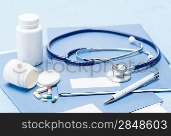 Medical equipment stethoscope, pen and medication over documents