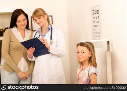 Medical examination at pediatrician girl measure height and weight