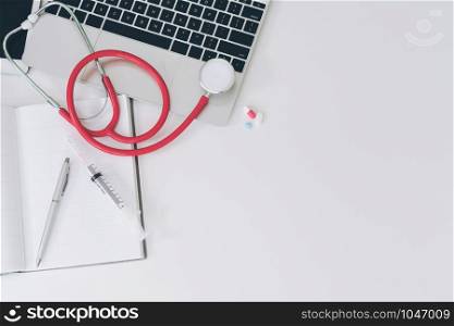 Medical healthcare backgrounds flat lay objects with copy space. Doctor stethoscope, medicine, laptop computer and notebook on white office table.
