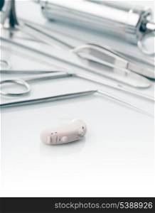 Medical instruments for ENT doctor on white and hearing aid, alternative to surgery