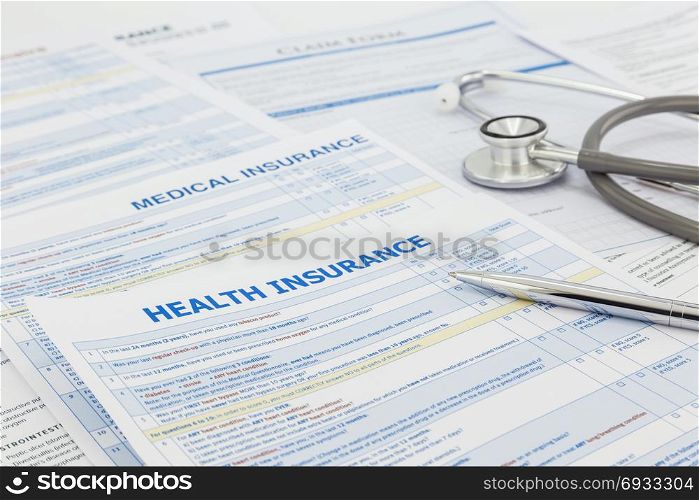 Medical insurance application, silver pen and stethoscope. Legal law contract and health insurance concepts.