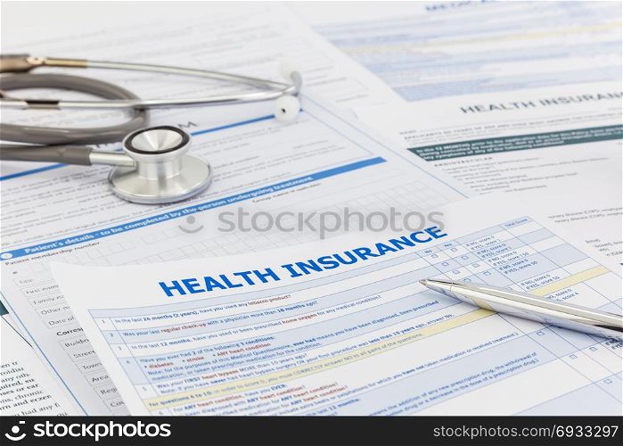 Medical insurance questionnaire, silver premium pen and clinical stethoscope. Healthcare survey and insurance information concepts.
