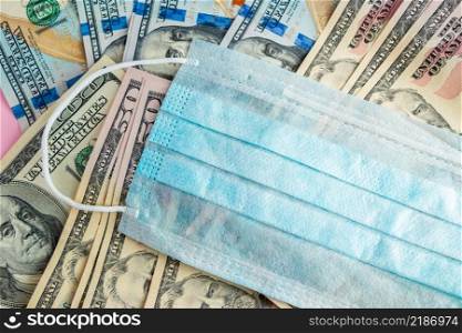 Medical mask and money. The concept of buying expensive protective respirators from the coronavirus. Illegal sale of surgical face masks.. Medical mask and money. Buying protective respirators from the coronavirus. Illegal sale of surgical face masks.