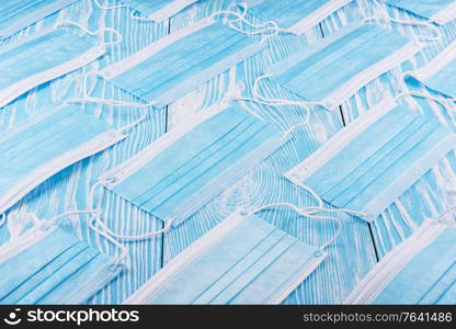 Medical masks on the blue colored background for protection from coronavirus. Epidemic and healthcare concept, pattern, flat lay.. Medical masks on the blue colored background