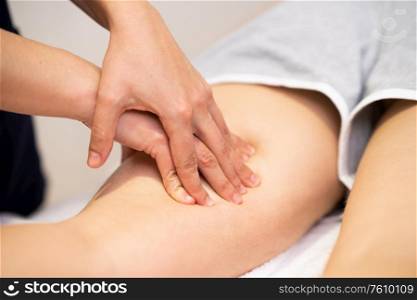 Medical massage at the leg in a physiotherapy center. Female physiotherapist inspecting her patient.. Medical massage at the leg in a physiotherapy center.