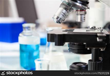 Medical or scientific research equipment and microscope in a laboratory environment with flasks and test tubes