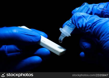 Medical personnel hand placing the secretions s&le into the SARS CoV-2 Rapid antigen test kit  ATK  with the extraction tube,Coronavirus infectious protective concept