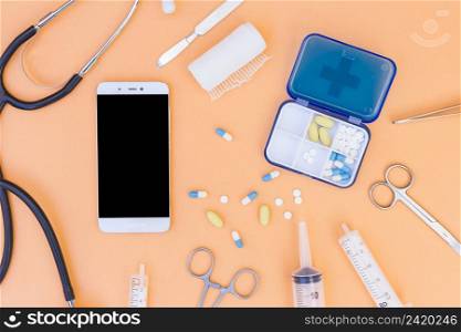 medical pill box stethoscope mobile phone medical equipment s orange background