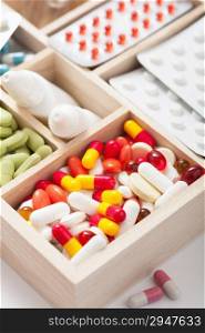 medical pills and ampules in wooden box