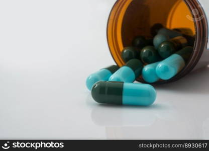 Medical pills spilling out of a toppled from pill bottle