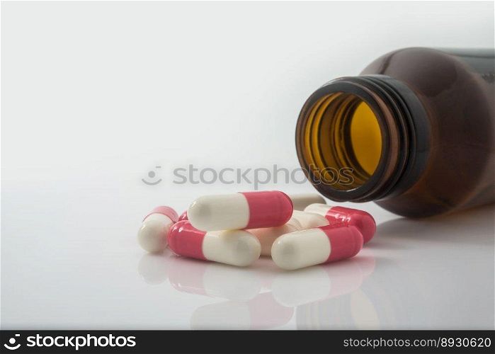 Medical pills spilling out of a toppled from pill bottle