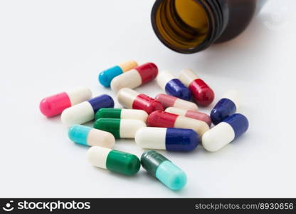 Medical pills spilling out of a toppled from pill bottle