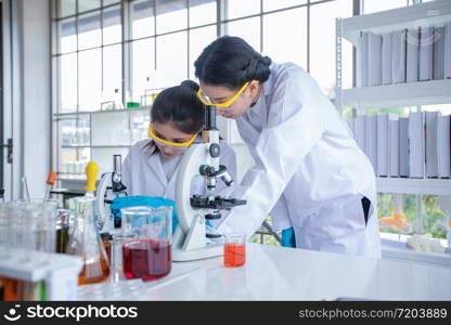 Medical Research and Scientists are working with a microscope and a tablet and Test Tubes, Micropipette and Analysis Results in a laboratory.