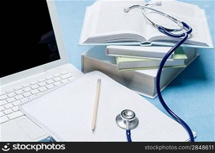 Medical research stethoscope lying on doctor book pen and paper