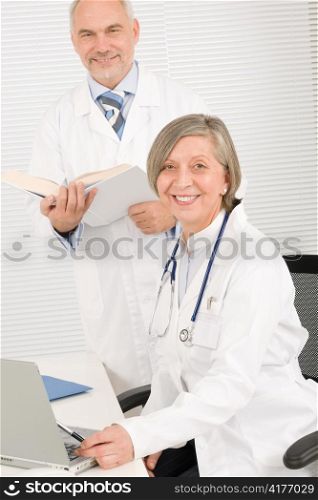 Medical senior doctor female work computer with professional male colleague