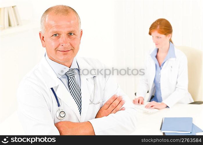 Medical senior doctor male with professional young female colleague office