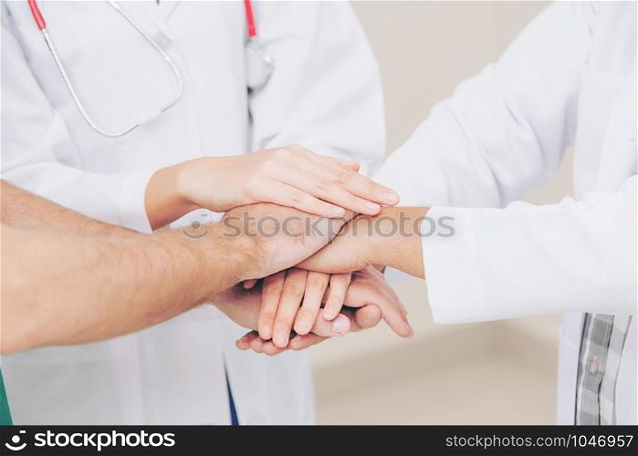 Medical service teamwork - Doctor, surgeon and nurse join hands together.