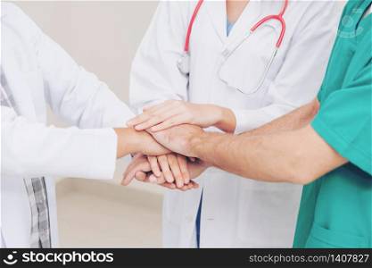 Medical service teamwork - Doctor, surgeon and nurse join hands together.. Doctor, surgeon and nurse join hands together.
