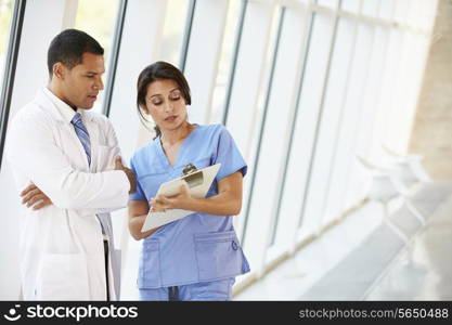 Medical Staff Having Discussion In Modern Hospital Corridor