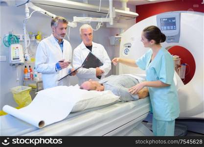 Medical staff stood around patient having scan