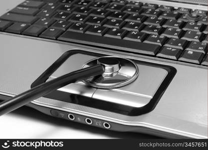 Medical stethoscope and open laptop