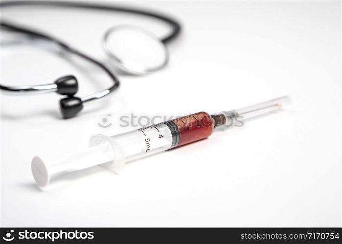 medical stethoscope and syringe with blood samples on a white isolated background