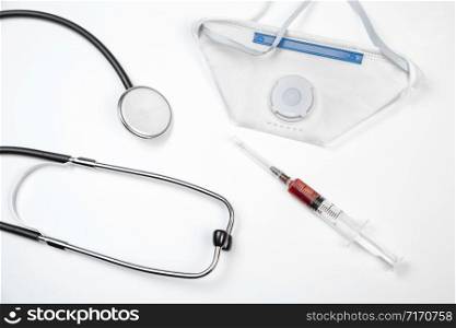 medical stethoscope, disposable mask and syringe with blood samples on a white isolated background