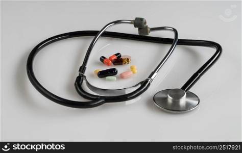medical stethoscope with pills on white background, isolated. stethoscope on white background