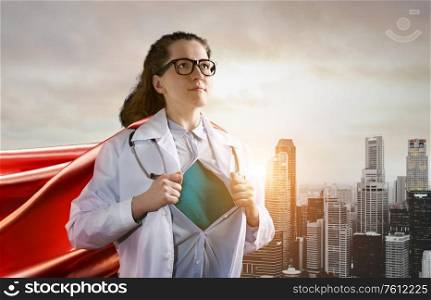 Medical superhero. Heroic doctor wearing glasses and red cape fighting with epidemic in city. Young woman. Brave medical staff concept.. Heroic doctor fighting with epidemic