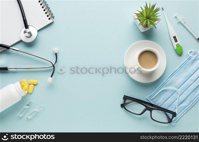 medical supplies with cup coffee succulent plant blue backdrop