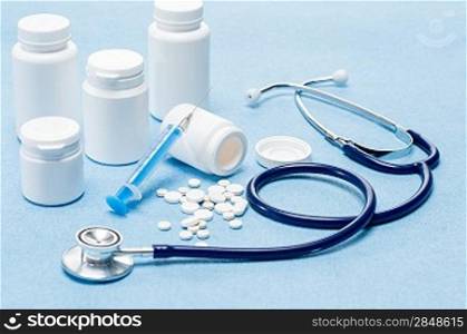 Medical supplies with spilled pills, injection and stethoscope