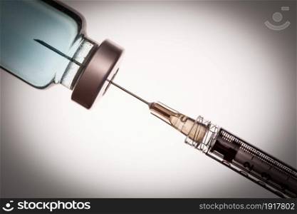 Medical Syringe Needle and Vaccine Vial Against White Background.