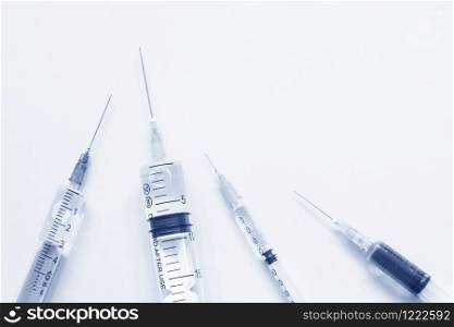 Medical syringes in blue silver monochrome.