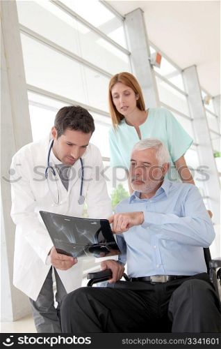 Medical team checking X-ray with patient
