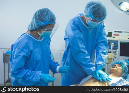 Medical team helping each other to help patient by making Cardiopulmonary Resuscitation in operation theatre of hospital