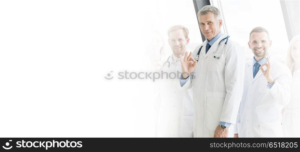 Medical team in hospital. Medical team of doctors and in hospital showing ok sign