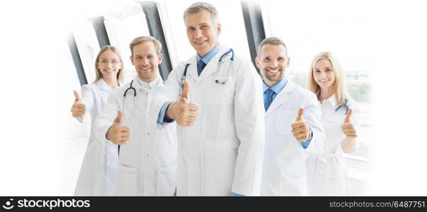Medical team in hospital. Medical team of doctors and in hospital showing thumbs up