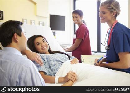 Medical Team Meeting With Couple In Hospital Room