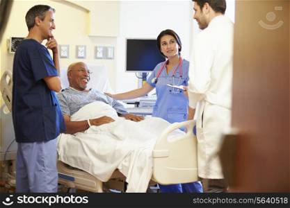 Medical Team Meeting With Senior Man In Hospital Room