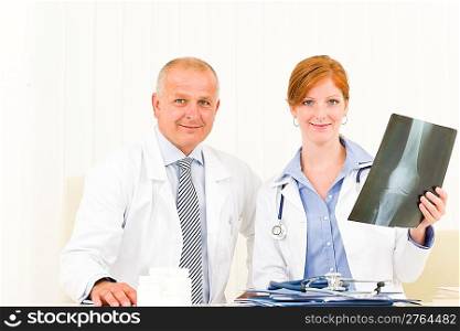 Medical team senior man with young female doctor hold x-ray