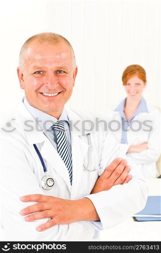 Medical team senior smiling doctor with professional female colleague portrait
