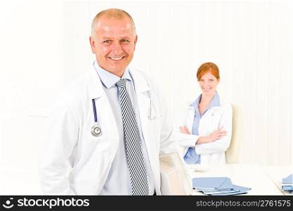 Medical team senior smiling doctor with professional female nurse portrait