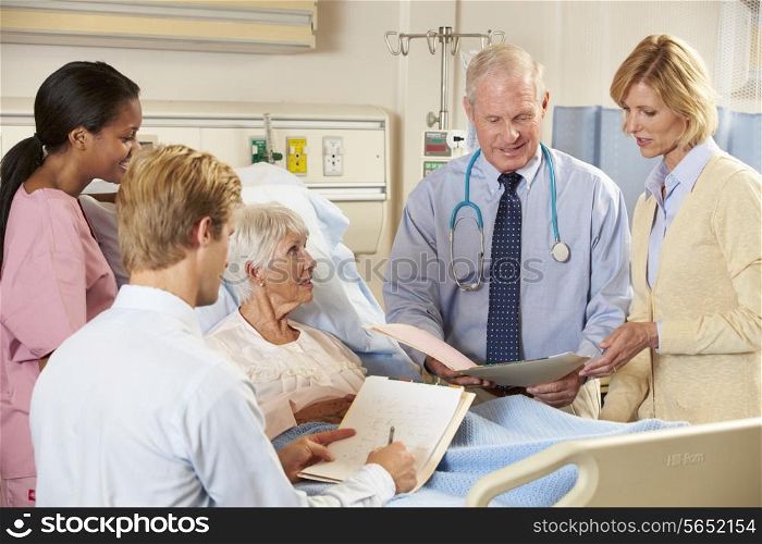 Medical Team Visiting Senior Female Patient In Bed
