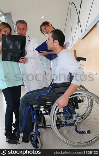 Medical team with handicapped person looking at X-ray